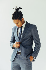 Young african american businessman standing on grey background