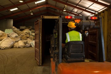 Worker driving a forklift in the junkyard