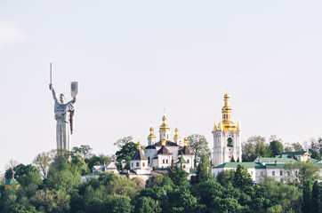 Fototapeta na wymiar The Motherland Monument and Pechersk Lavra Cathedral, Kiev, Ukraine. View from Dnipro river