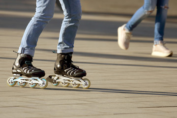 legs rolling around on roller skates in the background walking person.