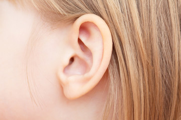 The little girl's ear is close-up. Isolated on white background. - obrazy, fototapety, plakaty