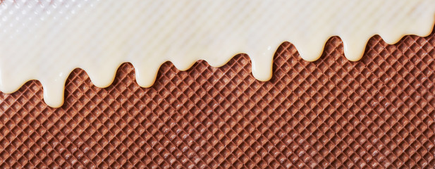 White hot chocolate on the wafer. Waffle covered with condensed milk close-up. White hot chocolate spreads on the wafer.