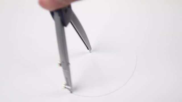 pair of compasses drawing circle on a paper.