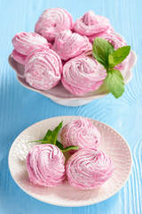 Homemade berry zephyr or marshmallow, on blue wooden background.