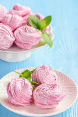 Homemade berry zephyr or marshmallow, on blue wooden background.