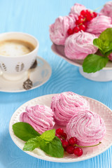Homemade berry zephyr or marshmallow, on blue wooden background.