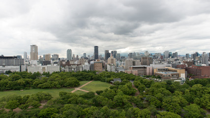 Aerial view of moat around castle park, Osaka business district and spectacular mountains surrounding the city from Osaka Castle.