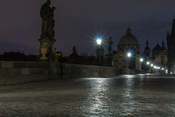 Karlsbrücke in Prag über die Moldau am Morgen. Nasses Kopfsteinpflaster.