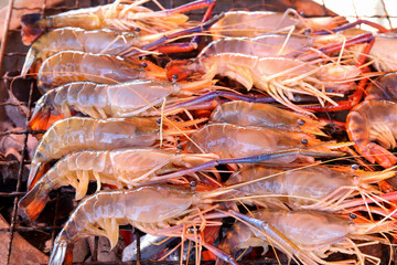 Close up of shrimp grilled on a hot charcoal stove in the party at camping.