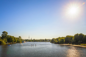 Alster Lake in Hamburg with people stand up paddle boards, with tv tower in the background