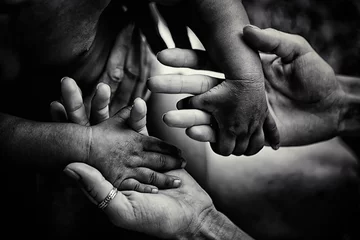 Kindern helfen. Freiwillige. Erwachsener hält kleine Hände eines kleinen afrikanischen Kindes. Unterstützung und Hilfe für Länder der Dritten Welt. Einheit in der Vielfalt. Kinder leiden unter Armut aufgrund schlechter Wirtschaft © Tverdokhlib