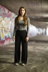 Full Length Portrait of a Young Woman Standing in a City Underpass