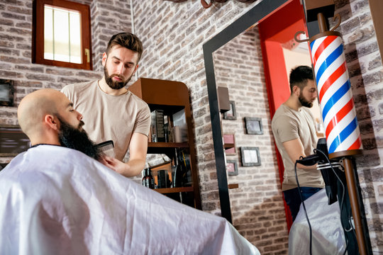 Hairdresser doing haircut of beard