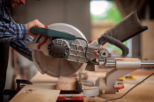 Carpenter work with circular saw for cutting boards, the man sawed bars, construction and home renovation, repair and construction tool