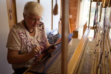 Senior woman using digital tablet at shop