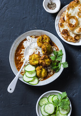Bottle gourd and zucchini fritters with rice and curry sauce. Healthy vegetarian food on dark background, top view