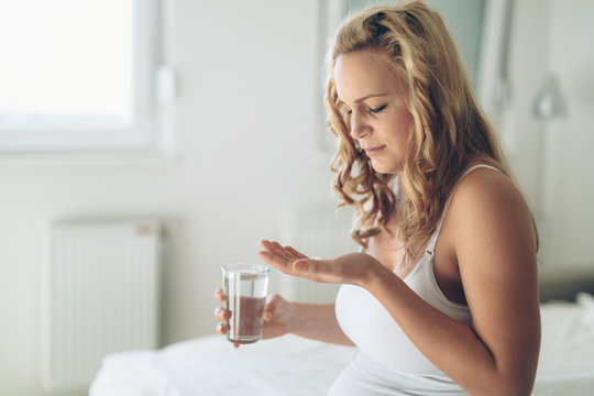 Picture of pregnant woman taking medication pills