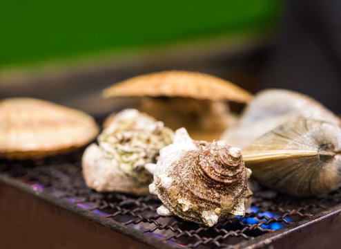 Mollusks are cooked in a cafe on fire, Tokyo, Japan.