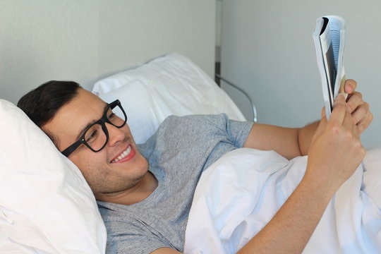 Man reading a magazine in bed 