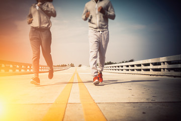 Man and woman running together on an empty road