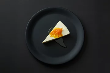 Crédence de cuisine en verre imprimé Plats de repas Dessert de gâteau au fromage avec de la confiture sur une plaque noire isolée sur fond noir