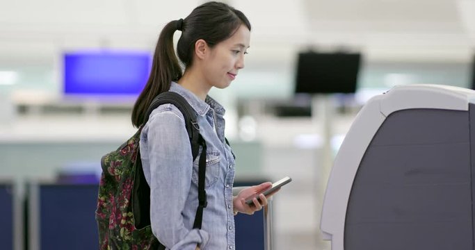 Woman using self check in counter in airport