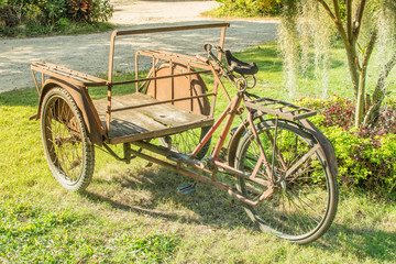 Fototapeta na wymiar Old tricycle Parked on the lawn