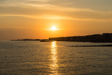 Children playing in the sea and enjoying sunset in Ostia Lido, Roma, Italy