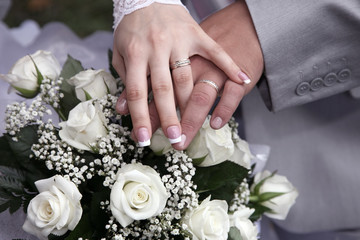 hands of bride and groom near wedding bouquet