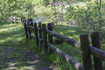 the road in the village is fenced with a wooden fence