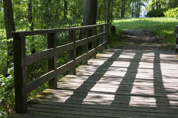 old wooden bridge across the river and on it a shadow from the bridge