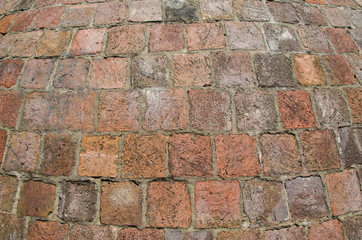 Old road pavement of the small rough granite tiles