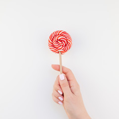Woman hand with red lollipop