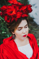 Gorgeous brunette woman with flower wreath, covered in red shawl