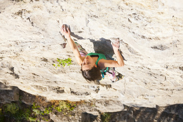 The woman climbs the rock.
