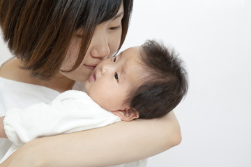 Obraz na płótnie Canvas 新生児にキスをする幸せなお母さんのイメージ