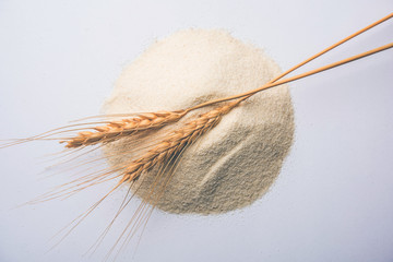 Raw unprepared semolina flour also known as Rava powder over white or moody background. selective...