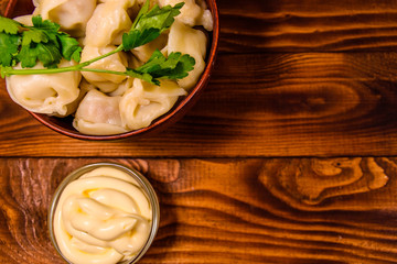 Fresh dumplings in ceramic bowl on wooden table. Top view