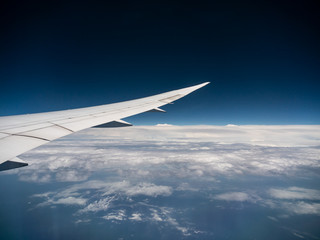 View from airplane window with blue sky and white clouds, background for travel holiday trip, Aircraft on the sky.