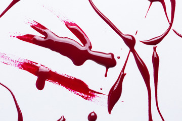 Nail polish on a white background in the form of strips and drops