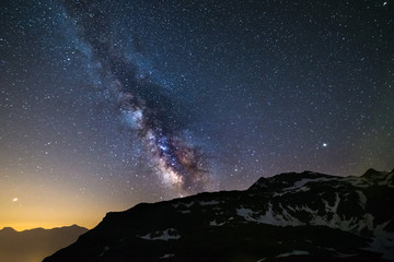 Astro night sky, Milky way galaxy stars over the Alps, Mars and Jupiter planet, snowcapped mountain range