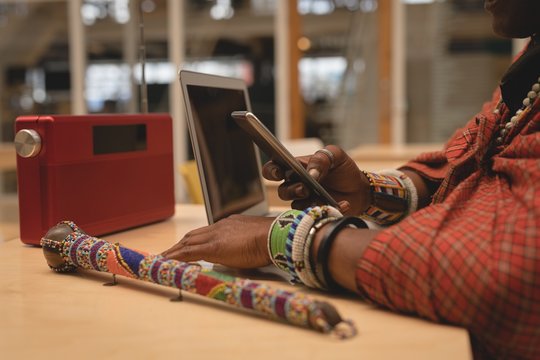 Maasai man in traditional clothing using mobile phone