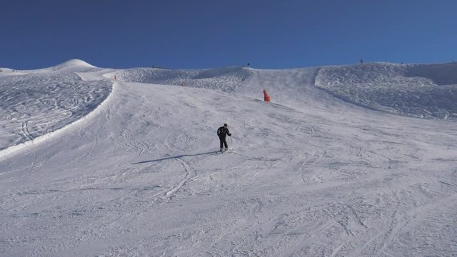 Skier Skiing Down The Slope, Turning Right And Left Fast, Brakes With Spray Snow