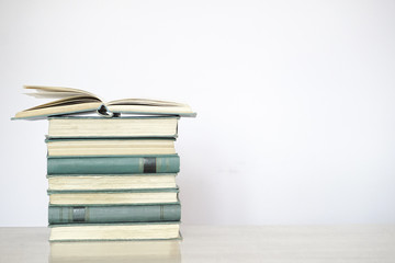 Open book, stack of hardback books. Back to school. Copy space.