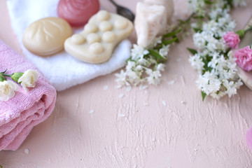 SPA and bathroom accessories. Photo in pink colors. Live flowers, soap, towel and wipes. Copy space.