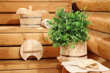 Birch broom on the wooden bucket and bath accessories.