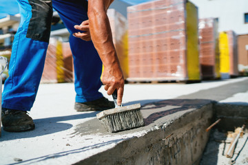 industrial worker on construction site laying sealant for waterproofing concrete on construction...