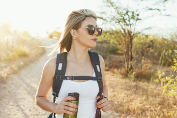 Happy young woman hiking with backpack