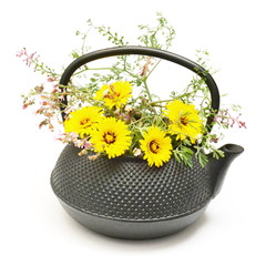 Black tea pot with yellow and pink flowers bouquet on white background