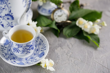 Obraz na płótnie Canvas A gorgeous tea cup with green tea and jasmine blossoms.